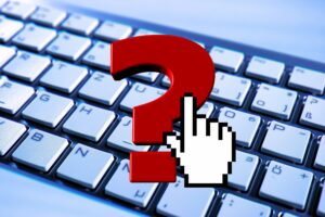 Et spørgsmålstegn med en stiliseret hånd over et keyboard